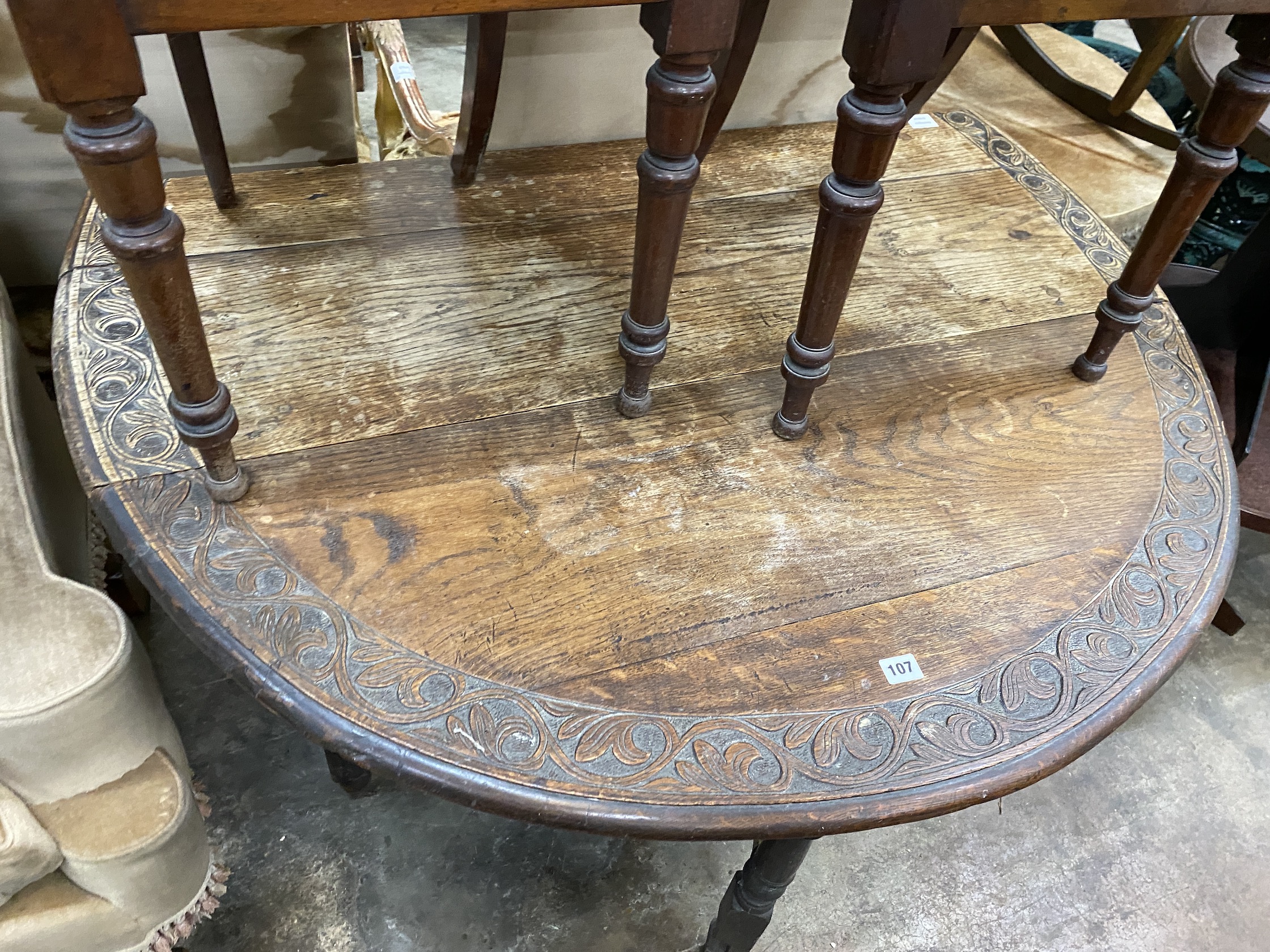 An early 20th century carved oak gateleg table, width 120cm, depth 44cm, height 74cm